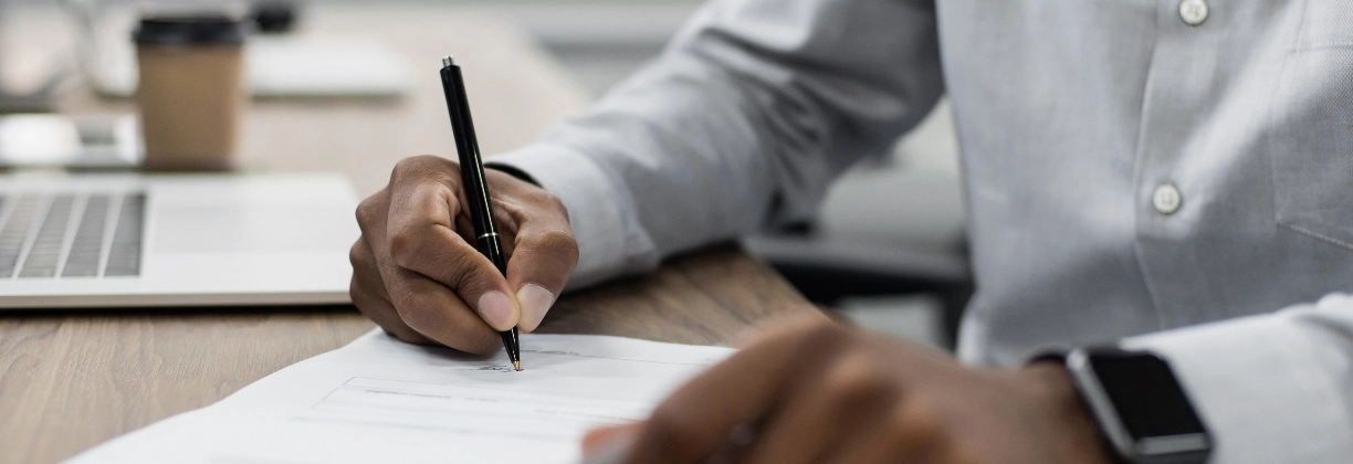 man signing document